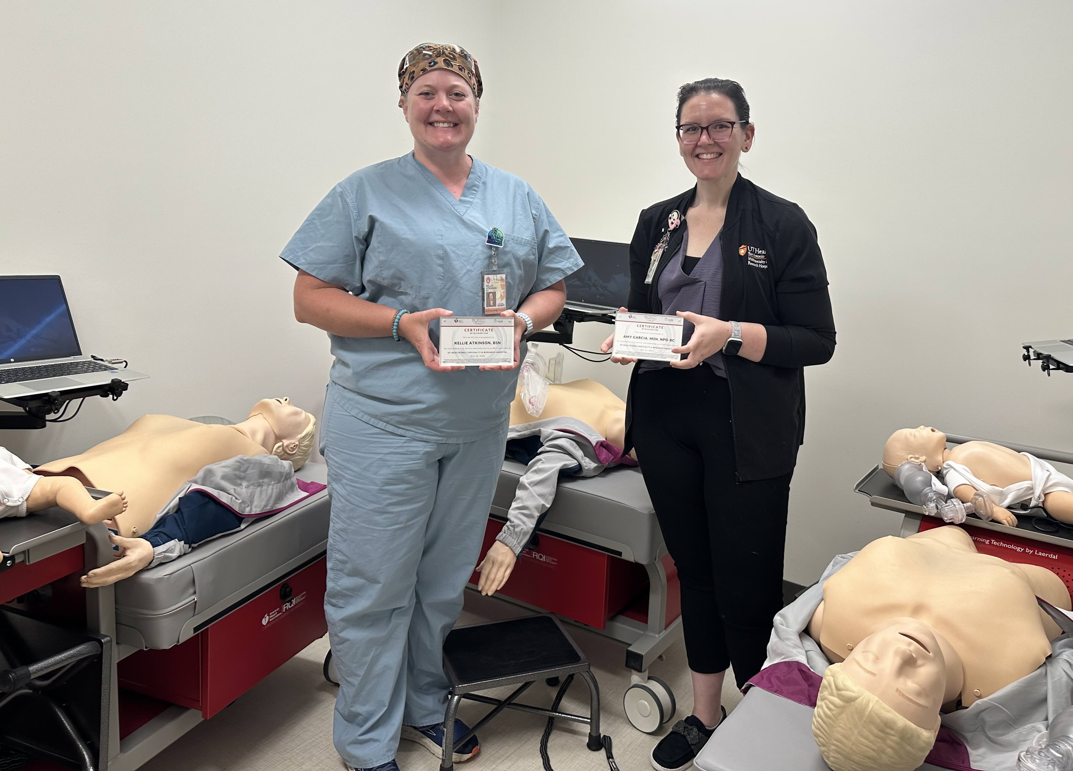 Amy Garcia and Kellie Atkinson hold their “super users” plaques by the national RQI program