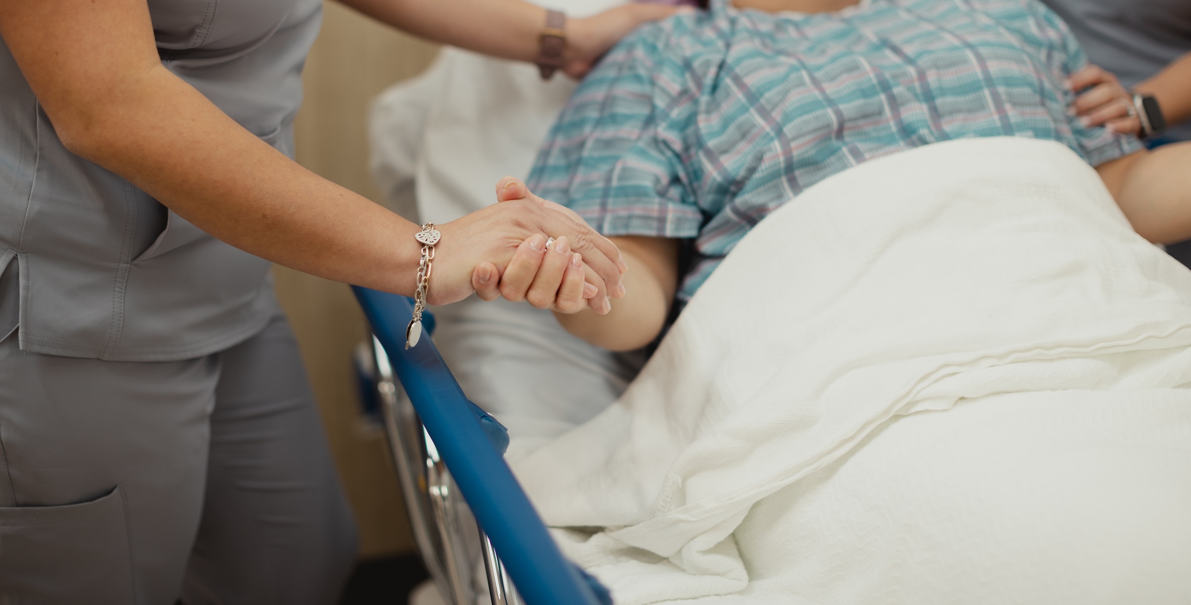 Hospital Staff Hold Patient's Hand