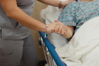 Hospital Staff Hold Patient's Hand